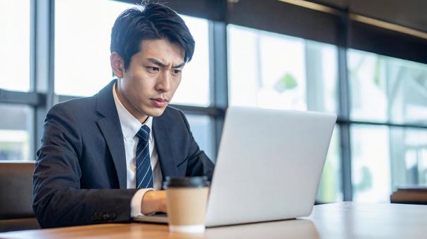 ノートパソコンで仕事をするサラリーマン ノートパソコンで仕事をするサラリーマンの写真