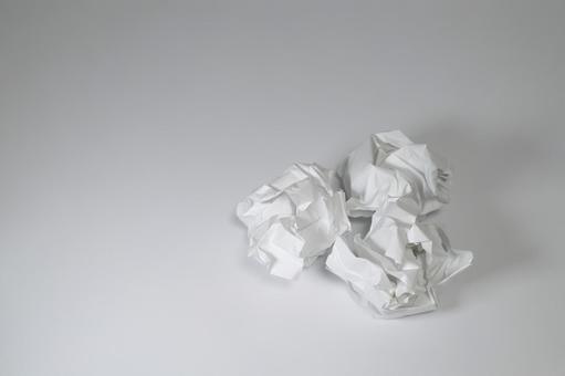 くしゃくしゃに丸めた白い紙の塊の写真