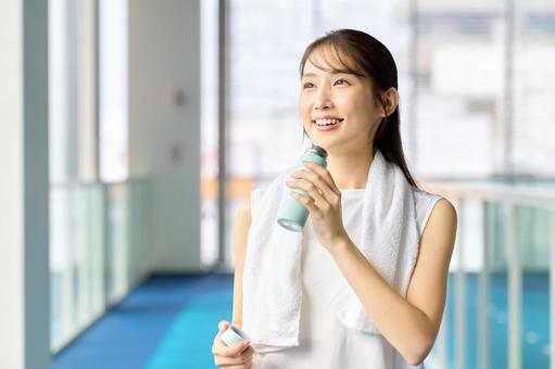 ジムで運動して水分補給する女性 トレーニング,スポーツジム,水分補給の写真素材