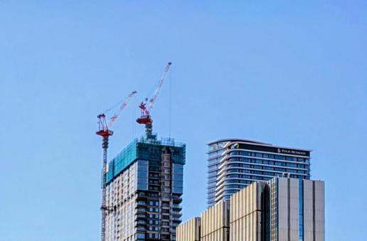 クレーンが動く建設現場 青空 高層ビル クレーンが動く建設現場 青空 高層ビルの写真