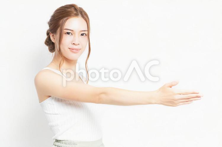 手を差し出すジェスチャーをする若い女性 女性,握手,協力の写真素材