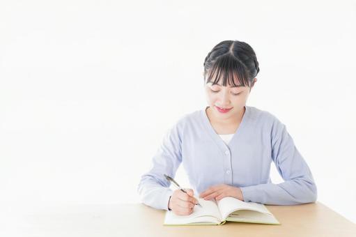 授業を受ける若い女子学生 授業を受ける若い女子学生の写真