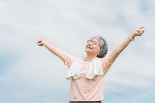 公園でストレッチ・深呼吸をする高齢者女性 深呼吸,柔軟体操,ストレッチの写真素材