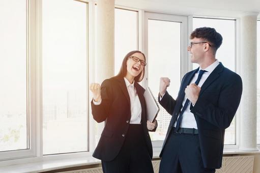 窓際でガッツポーズの男女 男女,ガッツポーズ,外国人の写真素材