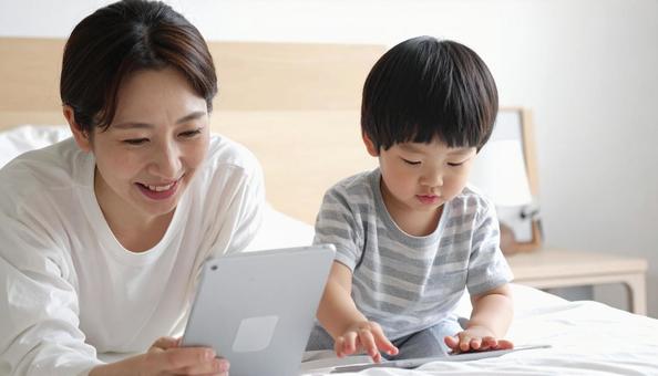 タブレットの画面を見る日本人親子 タブレットの画面を見る日本人親子の写真