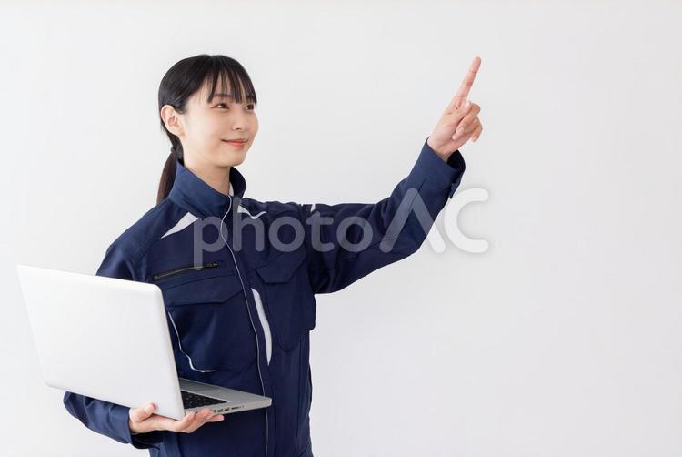 ノートパソコンを使う作業服の女性 女性,人物,日本人の写真素材