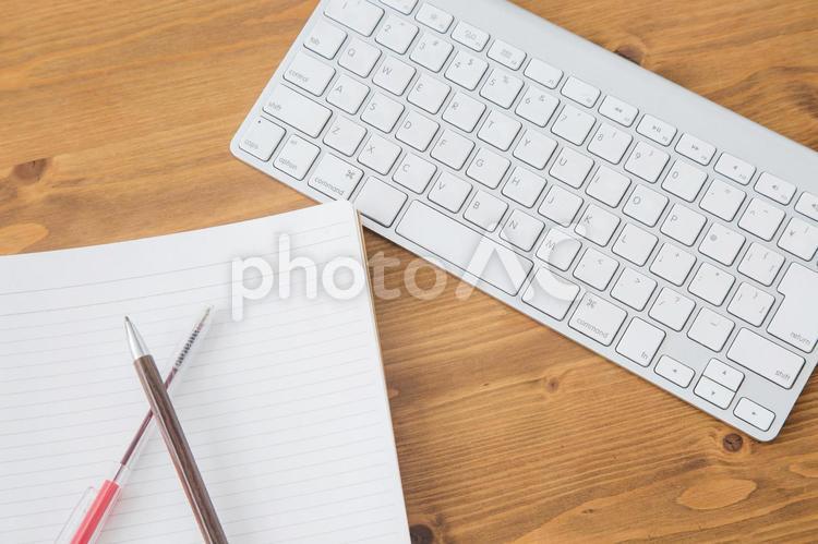テーブルと筆記用具 キーボード,ノート,ペンの写真素材