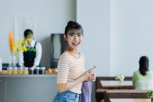 カフェに来店する若い女性 カフェに来店する若い女性 カフェ,女性,笑顔の写真素材