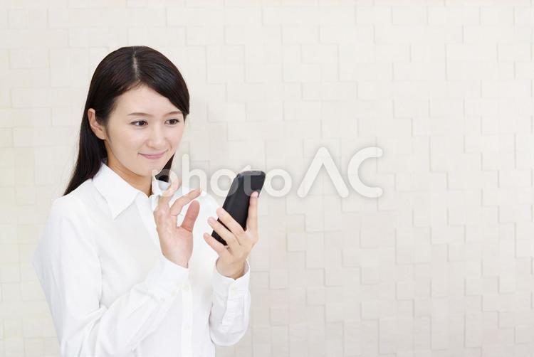 スマートフォンを持つ笑顔の女性 女性,スマートフォン,女の写真素材