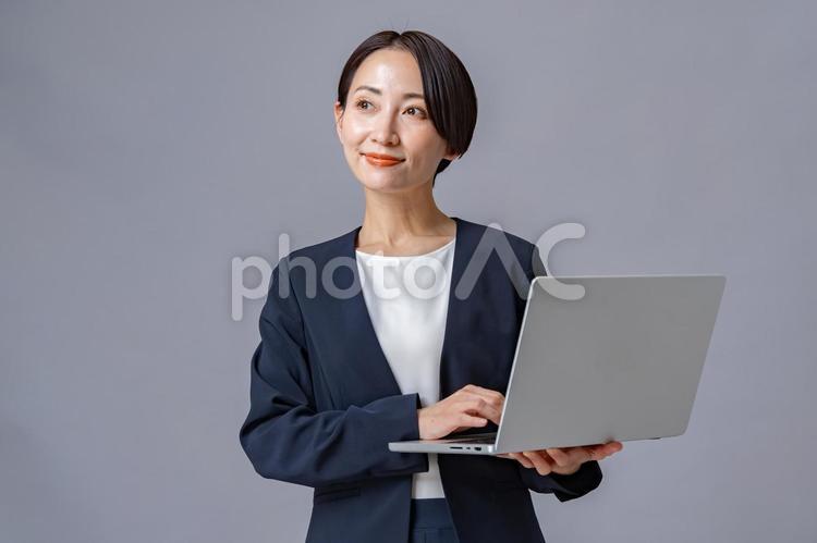 パソコンを持つ女性・グレーバック エージェントコンサル,アドバイザー,活動の写真素材