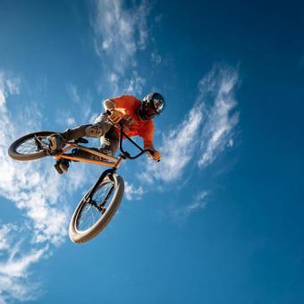 屋外で高く飛ぶプロBMXスタントライダー 屋外で高く飛ぶプロBMXスタントライダーの写真
