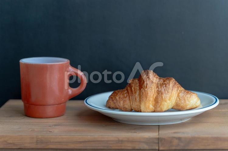 お皿に乗ったクロワッサンとコーヒーカップ クロワッサン,パン,バターの写真素材
