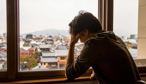 頭を抱えて落ち込む日本人男性 頭を抱えて落ち込む日本人男性の写真