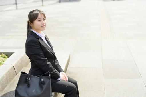 ベンチに座るスーツの女性 ベンチに座るスーツの女性 日本人,女性,20代の写真素材