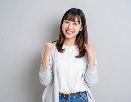 ガッツポーズで喜ぶ若い女性の写真