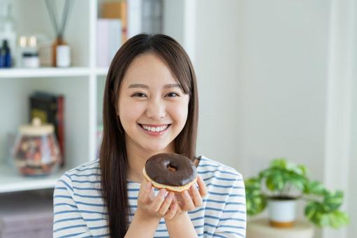 ドーナツを食べる若い女性 ドーナツを食べる若い女性 ドーナツ,スイーツ,ダイエットの写真素材