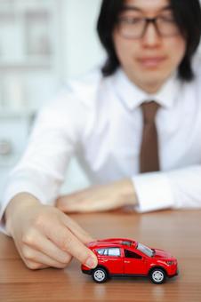赤い車に触れる男性のスタッフ 保険業,事務職,接客業の写真素材