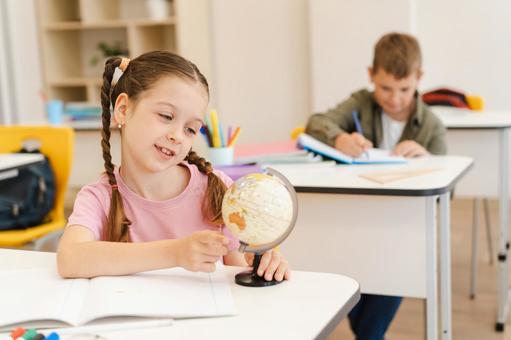 地球儀を見ている女の子と真剣にノートに書く男の子 男の子,女の子,子どもの写真素材