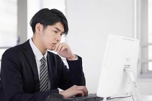 Japanese male businessman thinking while working on a computer, JPG Japanese male businessman thinking while working on a computer, business, office, businessman, JPG