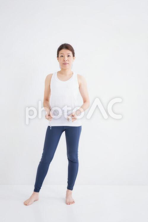 スポーツウェアをきた女性 ウエスト,ダイエット,メジャーの写真素材