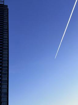 どこへ飛んでいく?きれいな飛行機雲 どこへ飛んでいく?きれいな飛行機雲 飛行機雲,高層ビル,コピースペースの写真素材