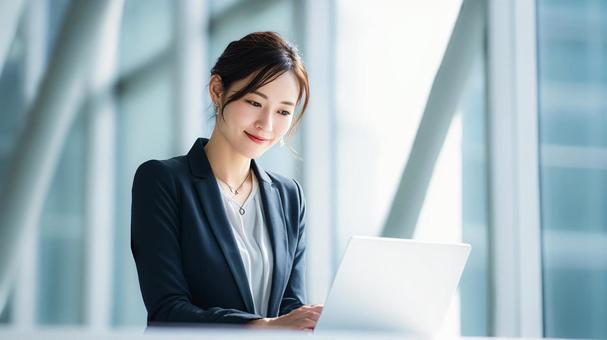 ノートパソコンを使用する女性会社員 ノートパソコンを使用する女性会社員の写真