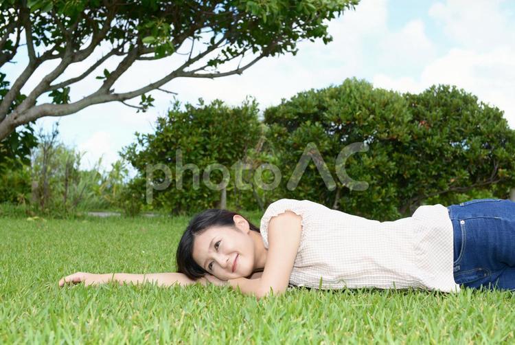 芝生の上でくつろぐ女性 女性,健康,アウトドアの写真素材