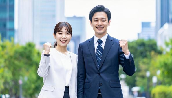 ガッツポーズする若い男女ビジネスパーソン ガッツポーズする若い男女ビジネスパーソンの写真
