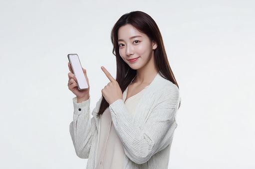 スマートフォンを提示する女性 スマートフォンを提示する女性の写真