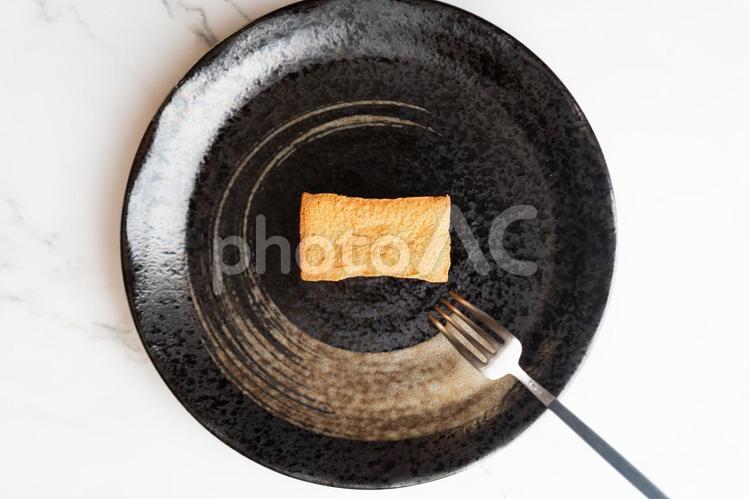 黒い皿に焼き菓子一つ② 焼き菓子,フィナンシェ,黒い皿の写真素材
