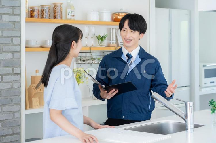 キッチンで女性に説明をする不動産業者 キッチンで女性に説明をする不動産業者 不動産,設計,女性の写真素材