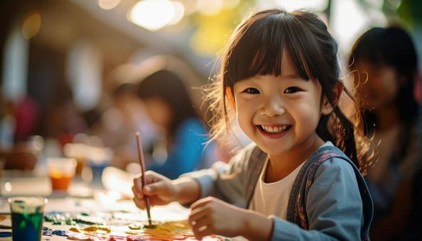 ペインティング中の日本人の子どもの笑顔 ペインティング中の日本人の子どもの笑顔の写真