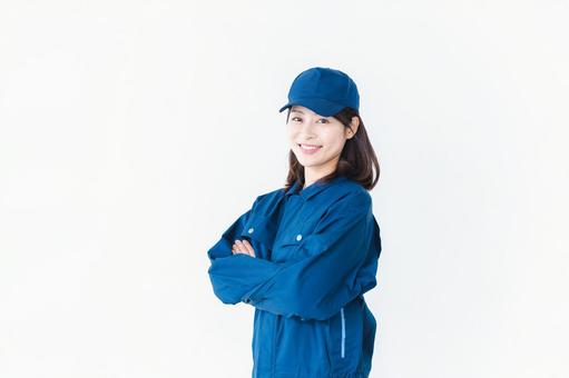 作業服を来て笑顔で仕事をする若い女性 作業服を来て笑顔で仕事をする若い女性 作業服,郵便,ウェアの写真素材