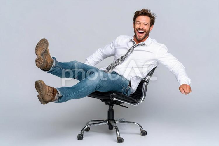 オフィスチェアで楽しげに笑うビジネスマン 男性,ビジネスマン,笑顔の写真素材