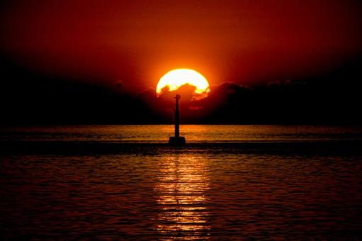 <素材>秋の海に静かに沈む夕日と灯台 <素材>秋の海に静かに沈む夕日と灯台の写真