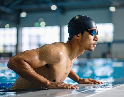 プールサイドに上がる競泳選手(男性) プールサイドに上がる競泳選手(男性)の写真