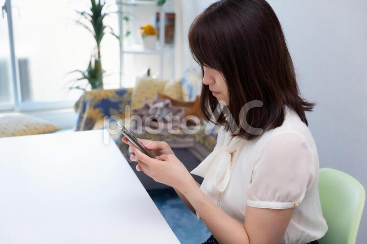 スマホを操作している女性 女性,スマートフォン,スマホの写真素材