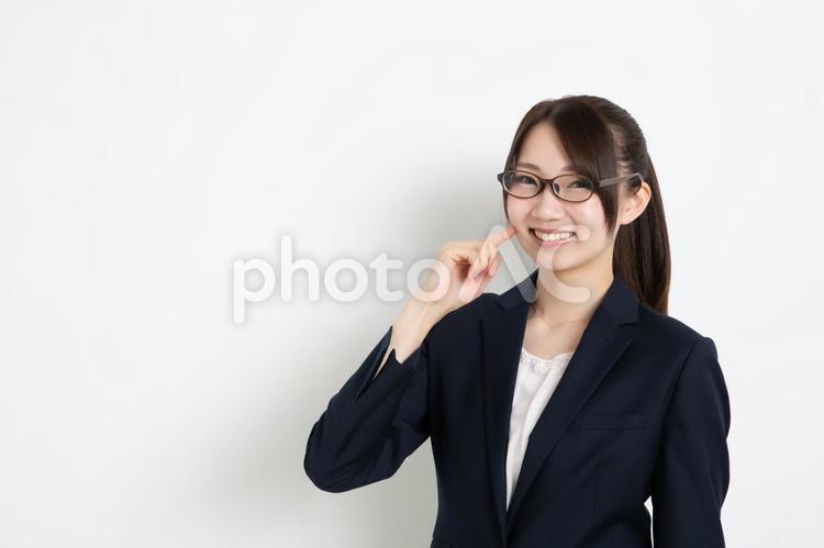 指を頬にあてて笑っているメガネのビジネスウーマン（コピースペース） 女,女性,日本人の写真素材