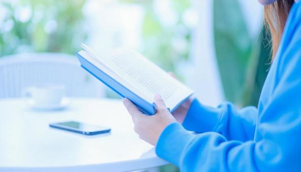カフェで読書する女性の手元アップ カフェで読書する女性の手元アップの写真
