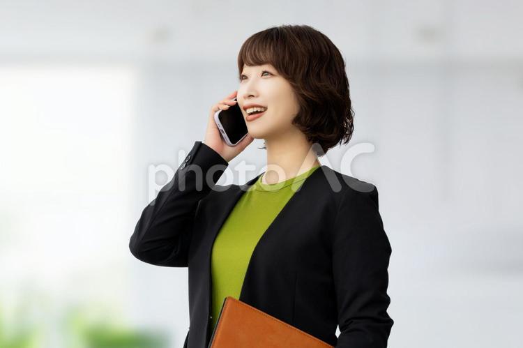 スマホで話す笑顔のビジネスウーマン 女性,ビジネス,スマホの写真素材