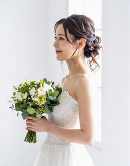 ウェディングドレスを着てブーケを持つ花嫁 ウェディングドレスを着てブーケを持つ花嫁の写真