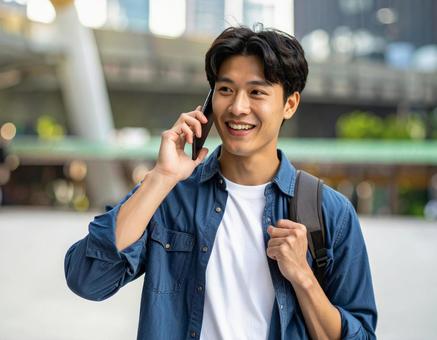 街中で電話をかける男性の写真