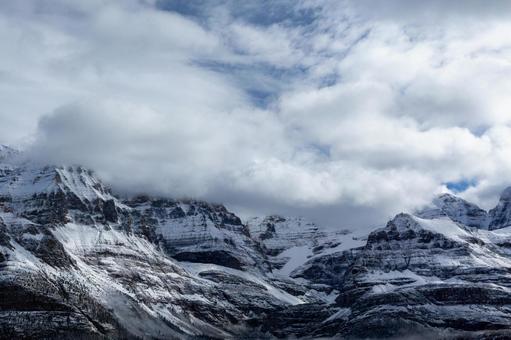 大迫力の雪山｜雲間の青空｜望遠写真 雲海,ロッキー,カナダの写真素材