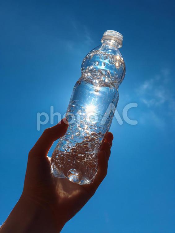 日光が差し込む透明なペットボトルの水 水,ペットボトル,手の写真素材