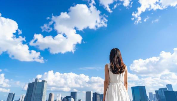 青空の下、遠くの景色を眺める女性の後ろ姿 青空の下、遠くの景色を眺める女性の後ろ姿の写真