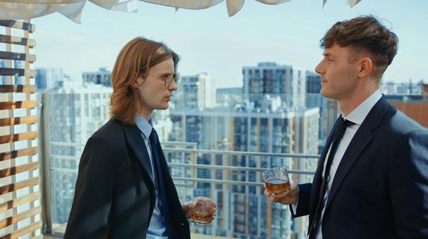 向かい合いグラスを持ち立つ男性の横顔 男性,外国人,真剣の写真素材