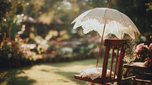 ガーデンチェアに置かれたレースの日傘と庭の写真