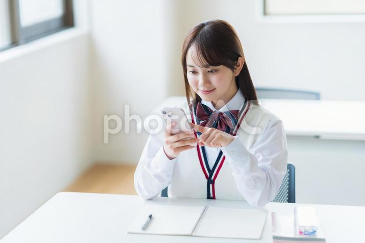 教室で勉強する学生 高校生,スマホ,笑顔の写真素材