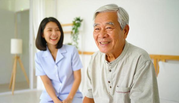 笑顔で話をする女性介護士と高齢男性 笑顔で話をする女性介護士と高齢男性の写真