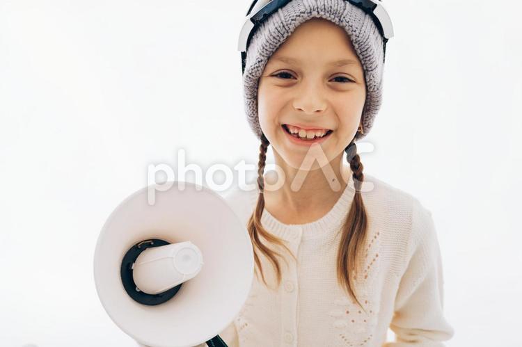 ニット帽にゴーグルをして拡声器を持っているカメラ目線の女の子 冬,女の子,外国人の写真素材